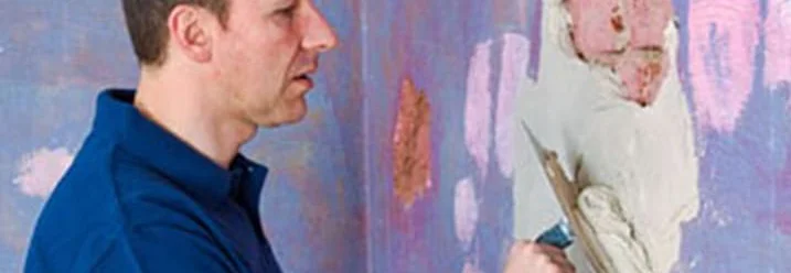 Person trägt mit Spachtel Spachtelmasse auf.